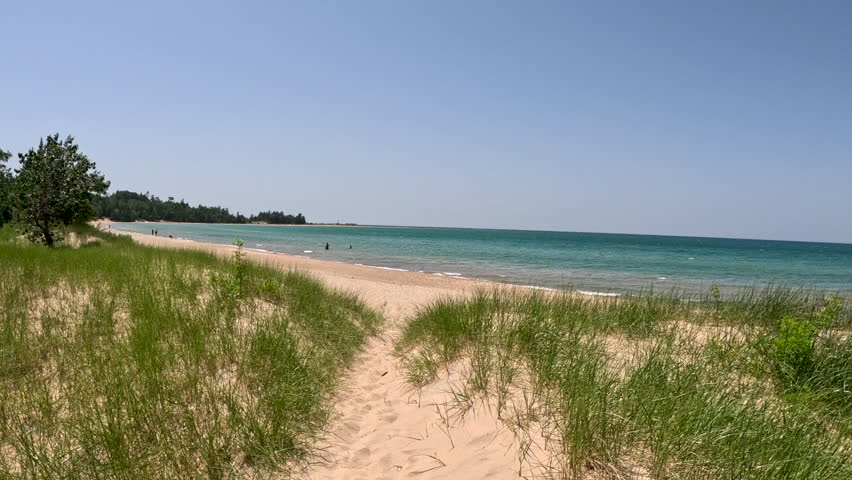 Sand Dunes on the Beach Lead to Lake Michigan. Climbing through sand dunes that lead to the beautiful beach on Lake Michigan. Unspoiled nature located within Wilderness State Park in Northern Michigan, USA.