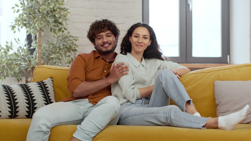 Couple Enjoys Cozy Moment Together on a Bright Yellow Couch in a Modern Living Room
