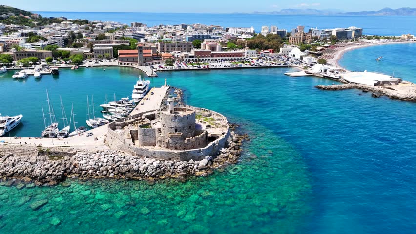 Aerial drone cinematic video of famous Saint Nicholas Fortress built in entrance of Mandraki harbor next to where Colossus of Rhodes was initially built, main town of Rhodes island, Dodecanese, Greece
