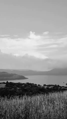Calm Lake and Rolling Hills Under Cloudy Sky, Peaceful Black and White Nature Landscape, Cinematic Scenic Video
