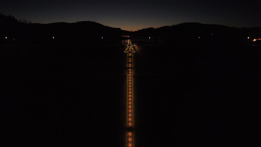 Cinematic drone flight along the illuminated Himmelstreppe stairs in Meschede at sunset. 333 steps leading to the Hennesee dam wall.