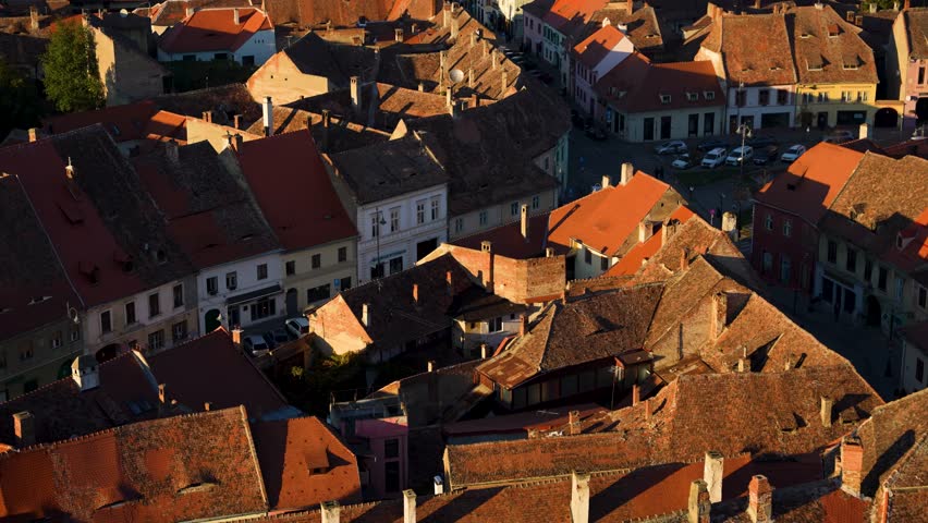 Sibiu, Romania - August 19, 2024: An aerial view captures the sprawling, terracotta-tiled roofs of Sibiu