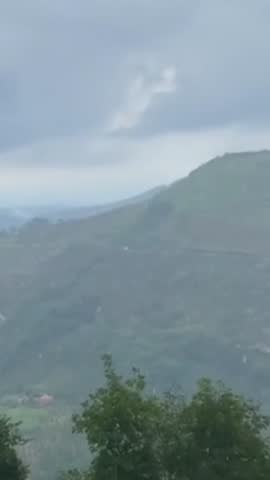 Misty mountain landscape with layers of hills fading into the distance under soft cloudy sky. Light fog and atmospheric haze create a calm, moody, and cinematic nature scene, ideal for travel, environ