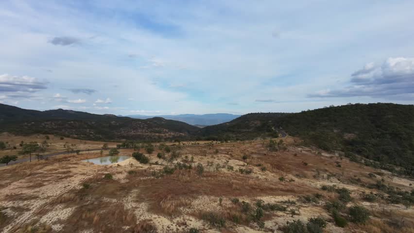 aerial drone footage flying forward over a rural valley with natural landcape and open scenery.