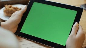 Businesswoman uses a tablet with a green touch screen in a modern cafe, ideal for technology, business, and digital workspace concepts. - Powered by Shutterstock - Get 15% off with code: PIKWIZARD15