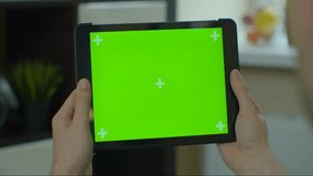 Man using a tablet with a green screen, close-up view for internet browsing, online activities, and digital content, ideal for chroma key replacement. - Powered by Shutterstock - Get 15% off with code: PIKWIZARD15