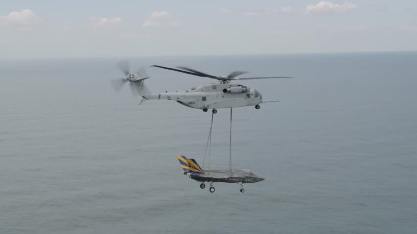 US Marines flying a CH-53K King Stallion heavy lift helicopter transport an F-35C Lightning II airframe from the F-35 Integrated Test Unit
