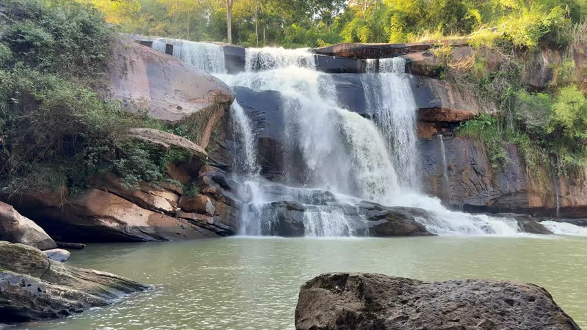 Rocks protrude from the waterfall during  winter season.
