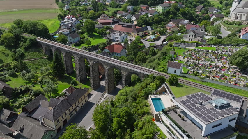 Aerial view of old viaduct in Austria. Old railway bridge in cityscape of streets of traditional tourist city.