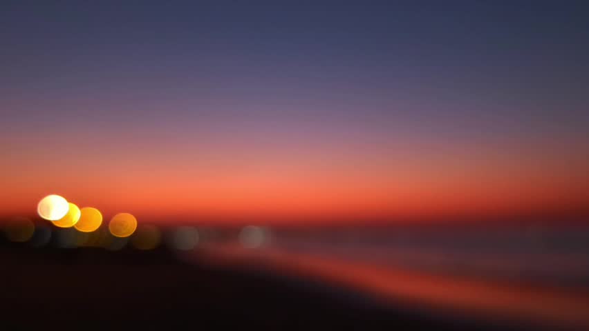Al Qurum beach at beautiful orange sunset in Muscat, Oman. Hajar mountains seen in the distance