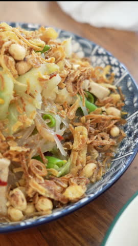 Close up of Luang Prabang style papaya salad with rice noodles. Spicy Asian salad popular in Laos and Thailand, traditional street food with fresh ingredients, chili, lime, and local flavors.