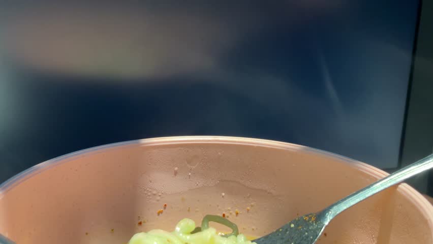 Close Up Instant Noodles on Fork with Steaming Hot Bowl