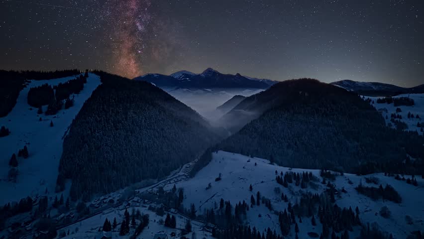 Aerial Night Hyperlapse of Milky Way over Winter Mountain Valley