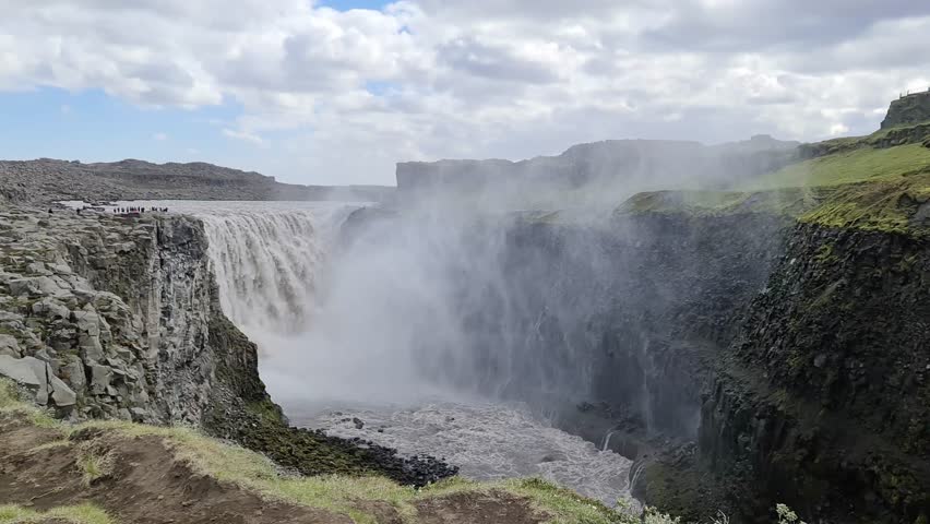 Majestic Gullfoss waterfall roaring down a rugged canyon under a cloudy sky in Southern Iceland