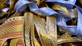 A close-up of metallic gold and silver decorative lace ribbons intertwined together, showing embossed patterns and reflective textures commonly used for gift wrapping or festive decoration. - Powered by Shutterstock - Get 15% off with code: PIKWIZARD15