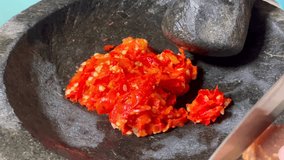 Making traditional spicy sambal chili paste using a stone mortar and pestle. - Powered by Shutterstock - Get 15% off with code: PIKWIZARD15