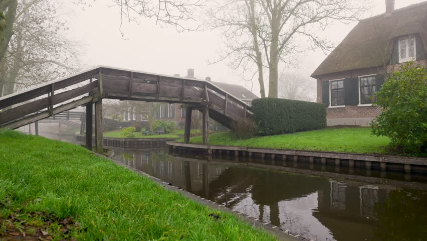 Serene Wooden Bridge Scene, Tranquil Country Footbridge Over Still Water And Lush Greenery