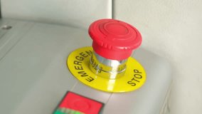 Close-up of a worker's hand pressing a red emergency stop button on an industrial control panel, representing an immediate halt to machinery for safety and operational shutdown in a factory - Powered by Shutterstock - Get 15% off with code: PIKWIZARD15