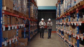 Two warehouse professionals walk through storage aisles while checking inventory data on a tablet, representing modern warehouse management and digital logistics systems.
 - Powered by Shutterstock - Get 15% off with code: PIKWIZARD15