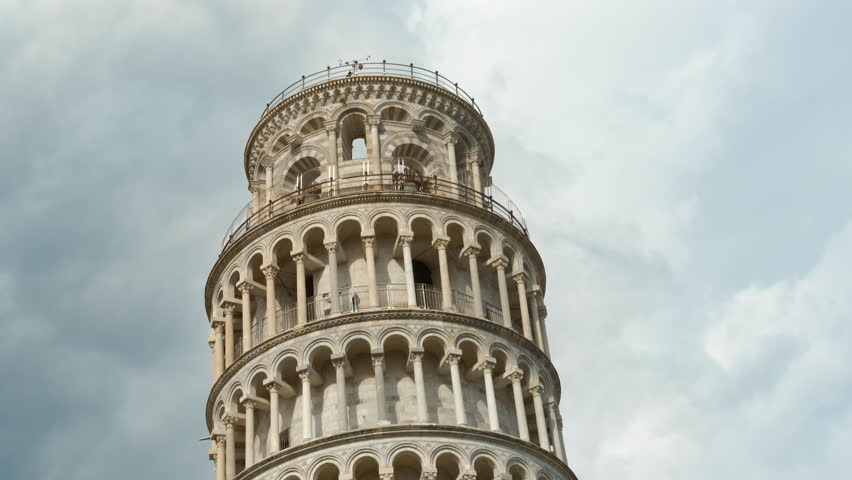 Leaning tower of pisa showing its tilt under cloudy sky. Majestic leaning tower rising against dynamic cloudy sky, highlighting architectural marvel of historic italian landmark
