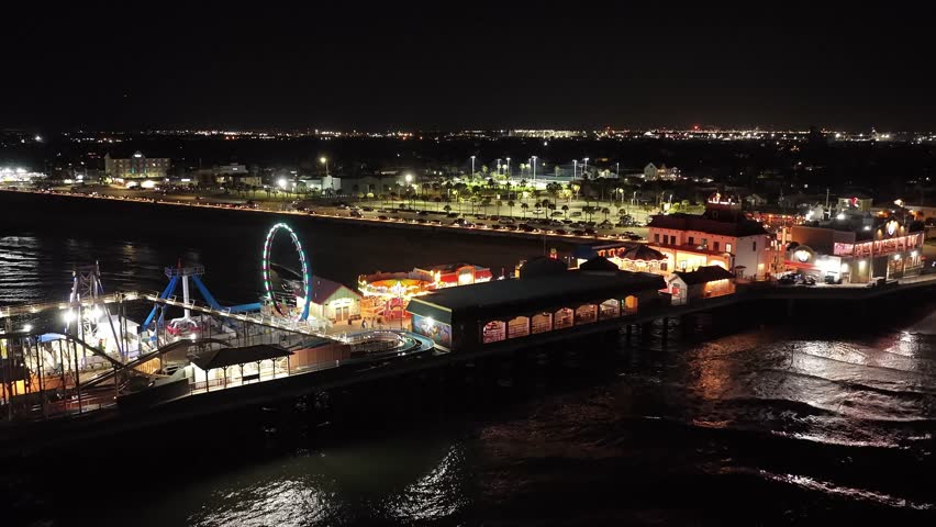 Galveston Island, Texas, United States – November 2024:
Night drone footage of the Galveston Island Pleasure Pier highlighting colorful lights, amusement park attractions, and waterfront reflections. The video illustrates the energy and visual appeal of this well-known Gulf Coast tourist destination.