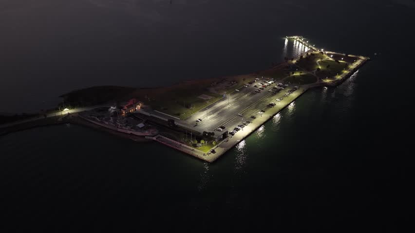 Galveston Island, Texas, United States – November 2024:
Drone footage at night capturing a wide establishing shot of a waterfront area, transitioning from land to open water with soft city lights in the distance.