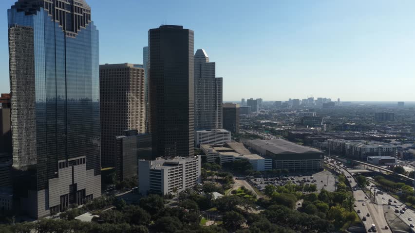 Houston, Texas, United States – November 2025:
Drone aerial footage of downtown Houston showing a cluster of glass and concrete skyscrapers rising above highways and tree-lined areas. The image documents urban growth and modern city infrastructure.