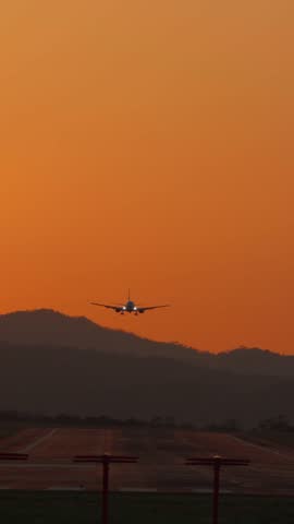 Vertical front view of a commercial airplane landing on the runway at sunset in Costa Rica