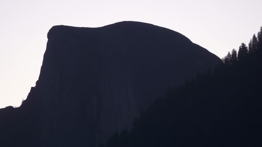 Half Dome stands in shadow during early morning light in Yosemite National Park.
