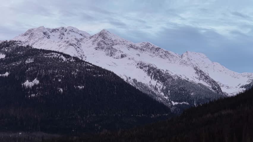 Majestic Snow-Capped Mountains Over Evergreen Forests in British Columbia, Canada