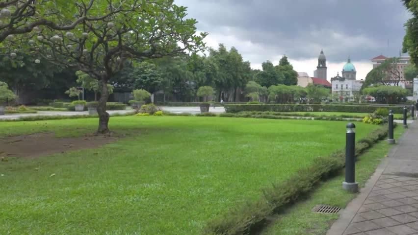4K video filmed inside Fort Santiago showing a green garden with trees and historical buildings a in the background in Manila, Philippines