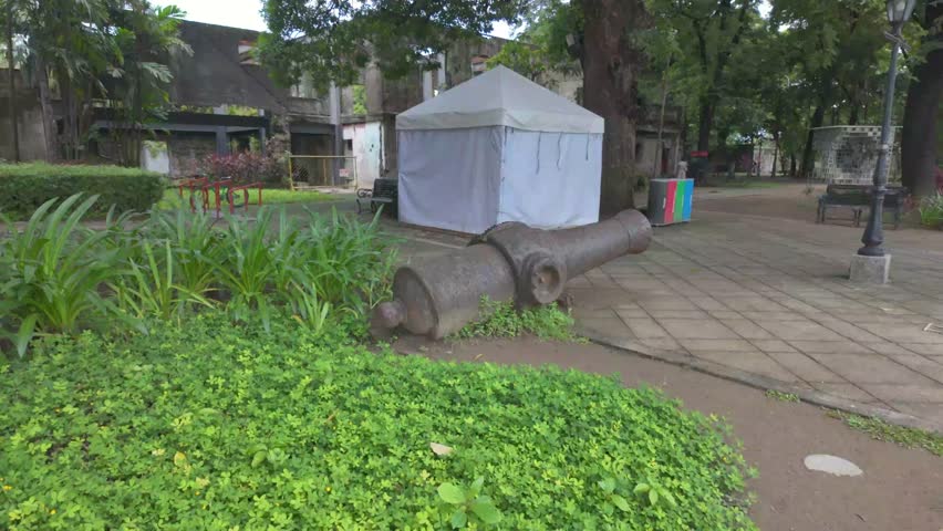 4K video of an old canon inside the Fort Santiago showing tropical garden and the old walls of the fort in Manila, Philippines