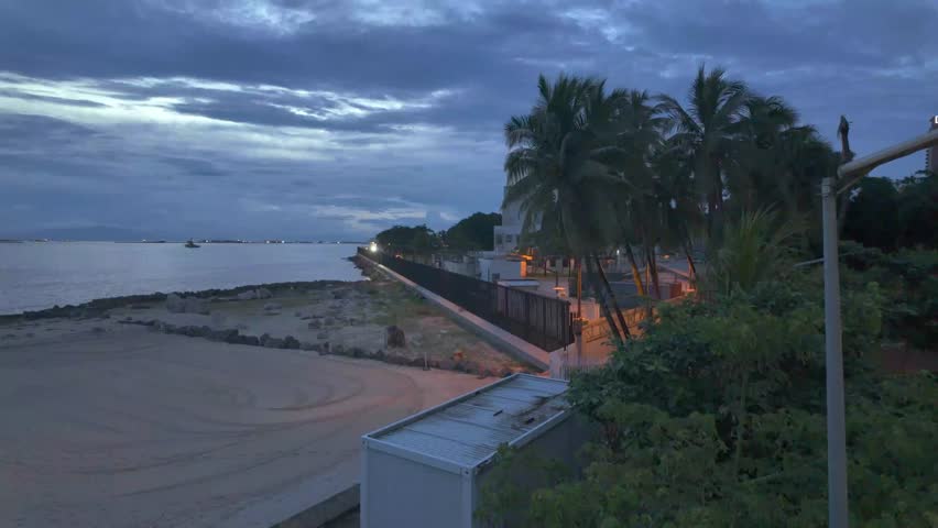 Sweeping view at dusk of a bay with boats and a sandy beach in the Philippines