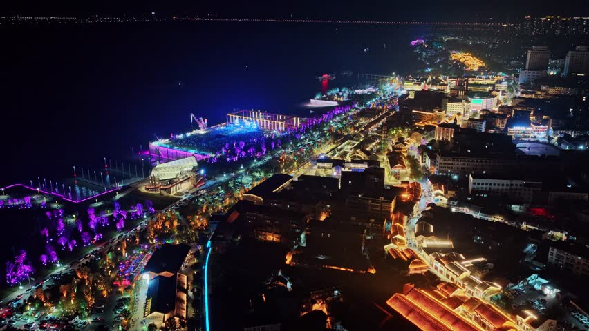 Aerial night view of music festival stage lights fans crowd in excitement.   Scene at outdoor concert with people dancing enjoying live performance in fest.