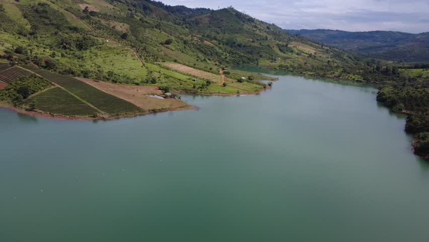 Aerial view of calm lake surrounded by rolling green hills