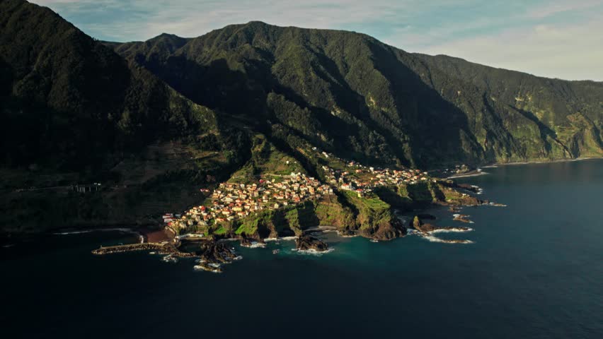 The city at the foot of the mountains on the seashore. View from the drone from the sea to the sea coast
