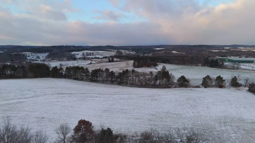 Aerial view of the Wisconsin countryside blanketed in fresh snow, with frozen fields and winding roads forming clean winter patterns.
