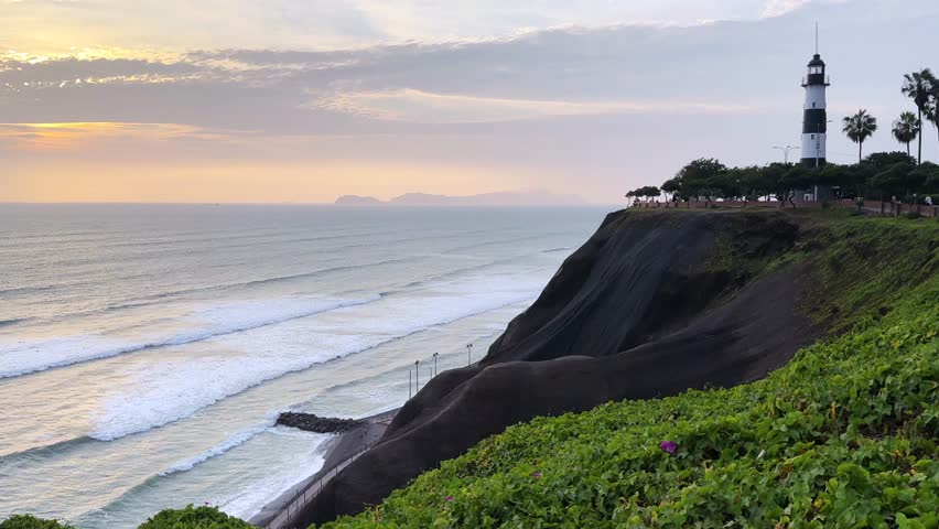 Historic La Marina navy Lighthouse Miraflores district Lima Peru Perú vibrant orange gold golden hour Sunset Pacific Ocean Love Park boardwalk Promenade cliffside landscape landmark static shot