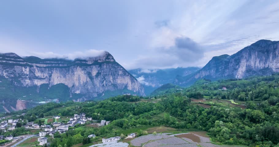 Aerial time-lapse over Enshi’s misty tea terraces, villages, and sheer cliffs in Qingjiang Grand Canyon, ethereal mountain landscape, Hubei province, China
