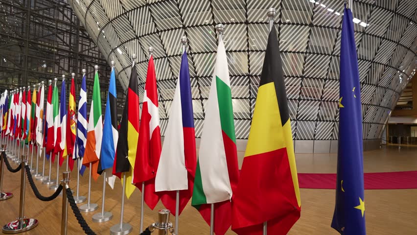 Following European flags in the EU Council building in Brussels, Belgium - Wide angle tracking shot