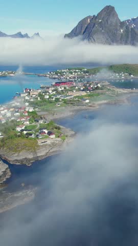 Aerial shot flying over the misty village of Reine on the Lofoten Islands in Norway