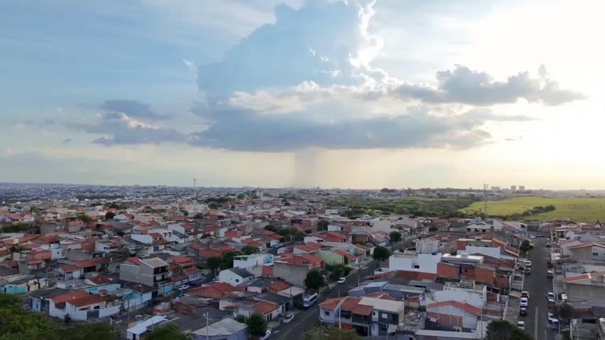 Dramatic drone shot of a localized rainstorm over a suburban neighborhood in Sorocaba, Sao Paulo