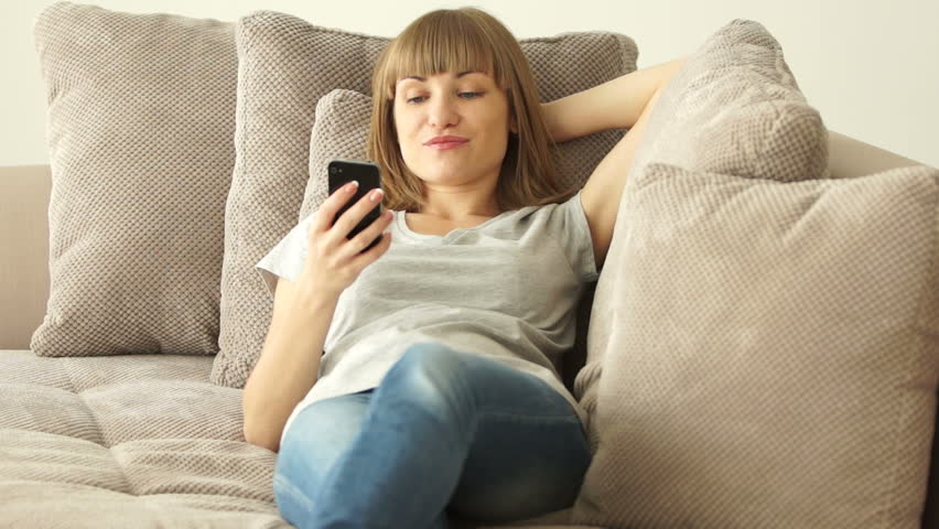 Girl lying on sofa and holding  phone
