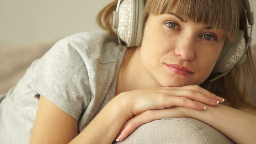 Girl sleeping on the couch and listen to music. Closeup
