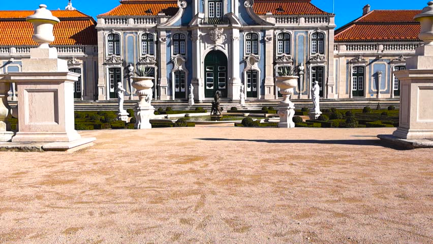 Sunny view of the Queluz National Palace with elegant baroque facade, fountains and manicured formal gardens, no people visible