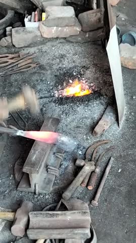 Traditional Blacksmith Forging a Metal Tool on an Anvil.