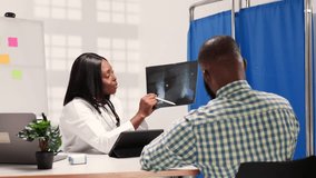 African female doctor explains an X-ray to a male patient in a hospital - Powered by Shutterstock - Get 15% off with code: PIKWIZARD15