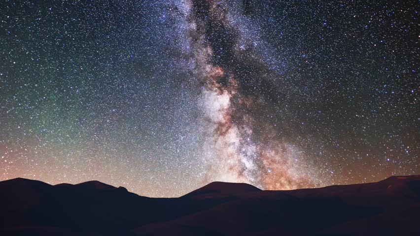 Rocks and mountains under milky way galaxy timelapse. Beautiful night sky landscape. 