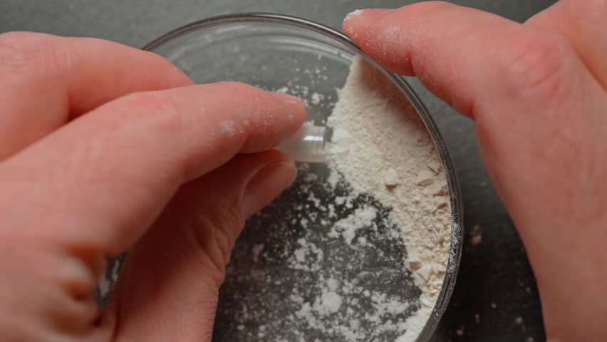 Drug dealer packing powder of synthetic opioid drug of fentanyl in the gelatin capsule for sale on the streets or parties. Toxic drug crisis and struggle with an addiction.
