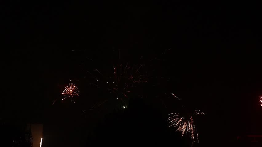 Bright glowing multicolor fireworks show and festival in the night sky.